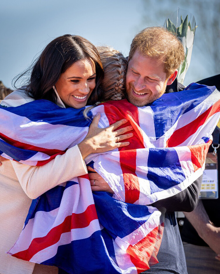 Меган, герцогиня Сассекская, и принц Гарри, герцог Сассекский, обнимают участника во время второго дня Invictus Games 2020 в Zuiderpark 17 апреля 2022 года в Гааге, Нидерланды